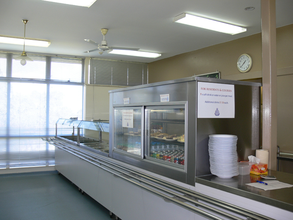 Food service area comprising mainly of stainless steel, including food warmers, fridge and bench.