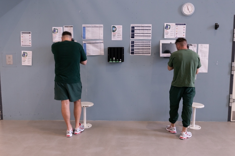 Two men side by side on telephones