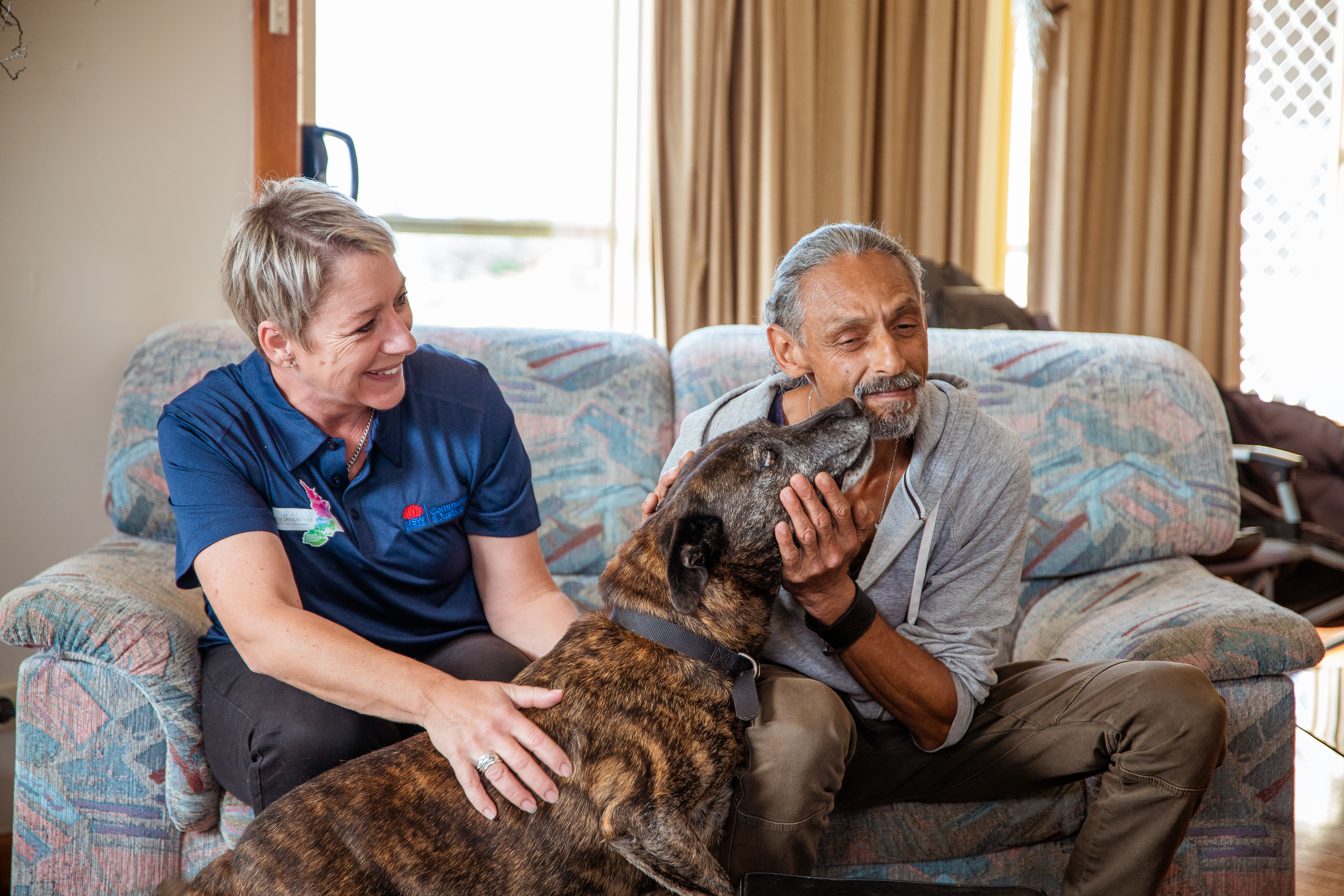 Yasmina giving a pat to dog Grizzly after finding him and his owner a home