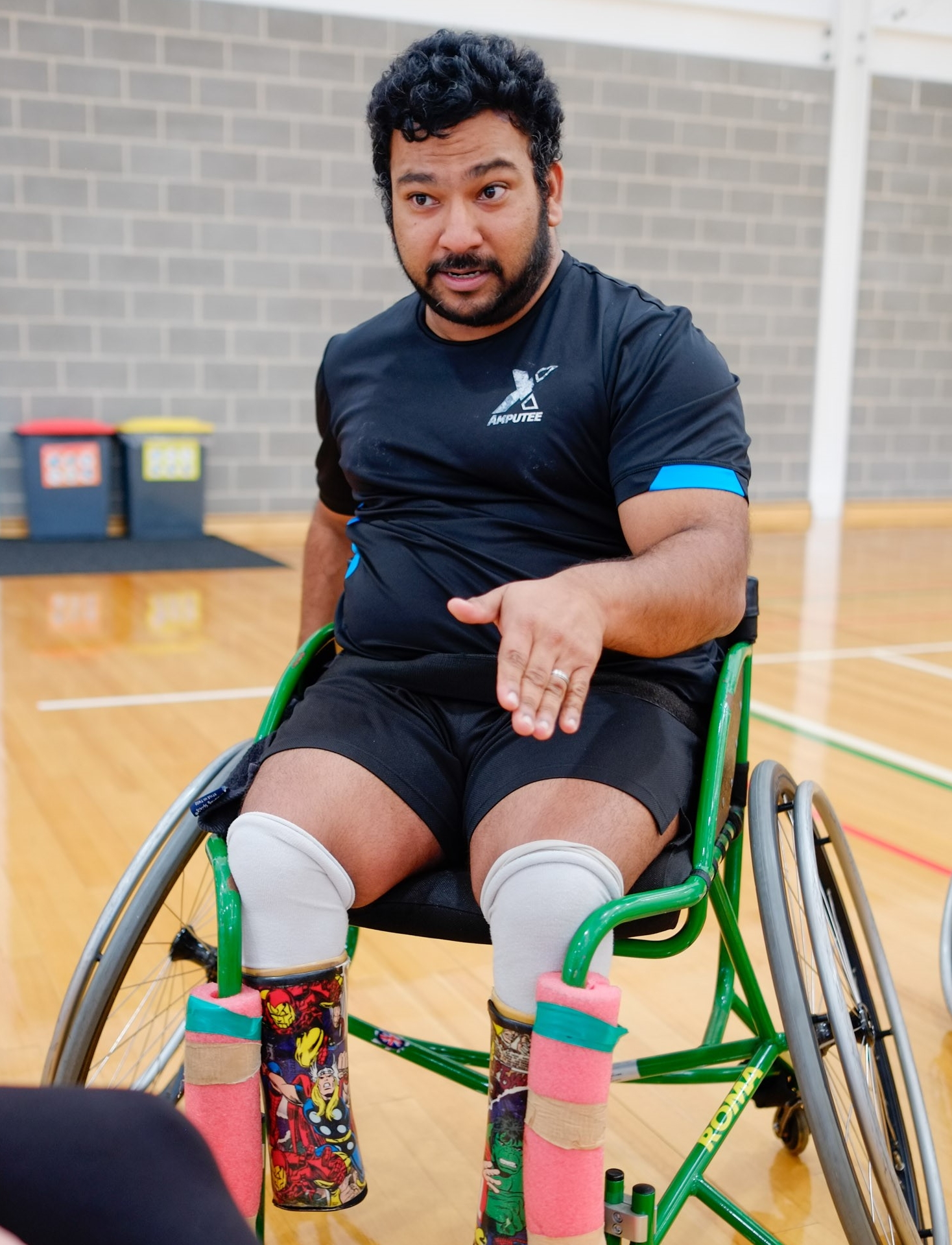 An image of a male staff member playing wheelchair basketball