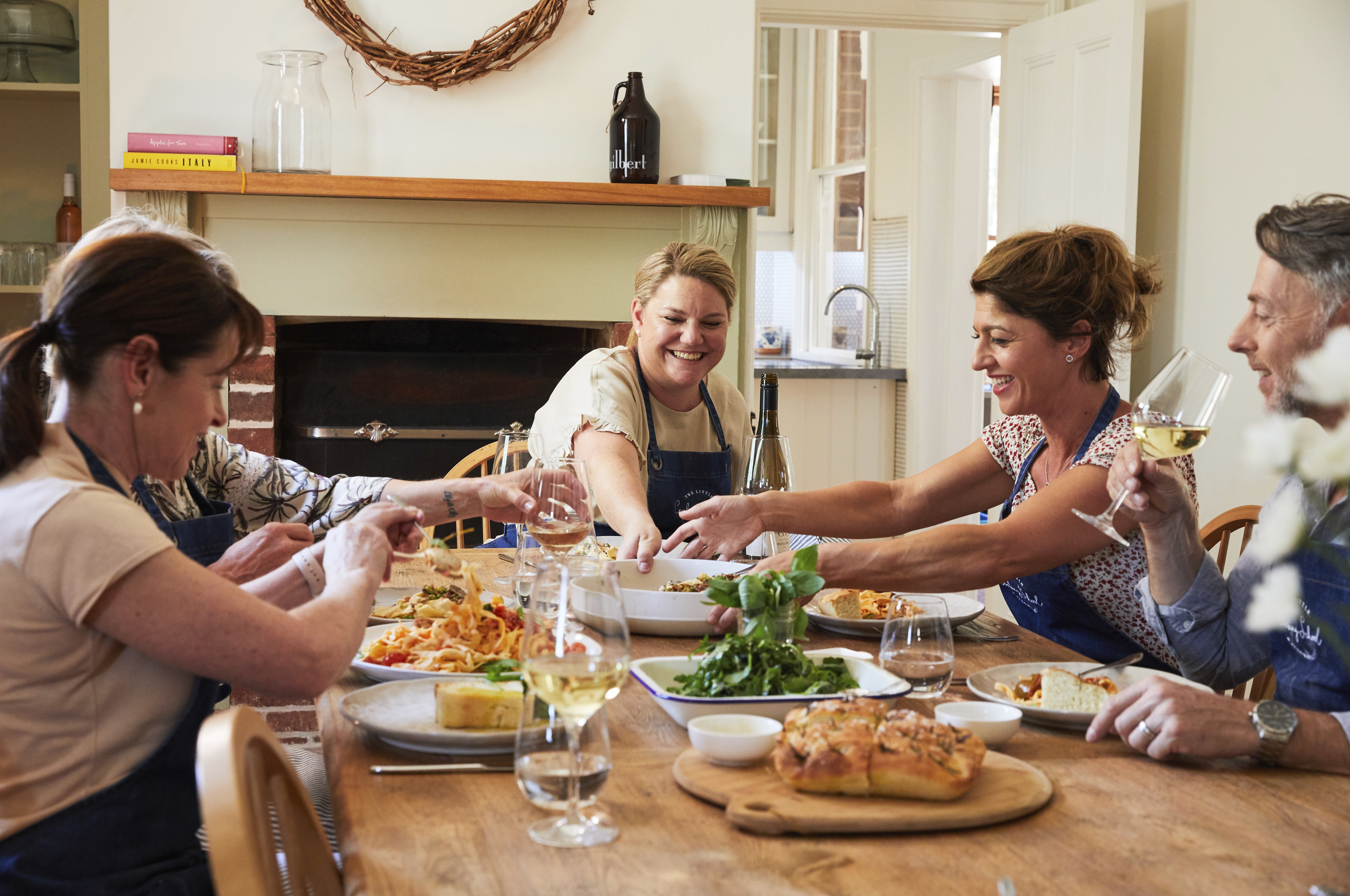 A photo of people sharing a meal around a table at The Little Cooking School