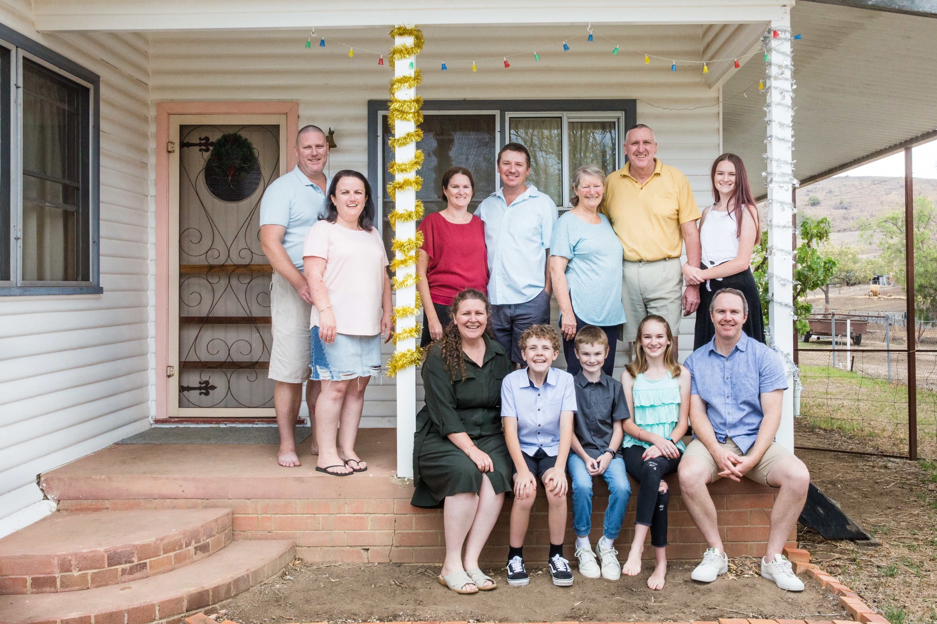 A big family picture outside a house