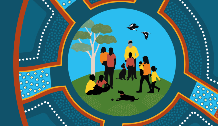 A large inter-generational family is spending time together outdoors under the canopy of a gum tree. They are sitting and standing on a hill, and there are two dogs with them. The sky is blue. Two black and white birds fly above them.