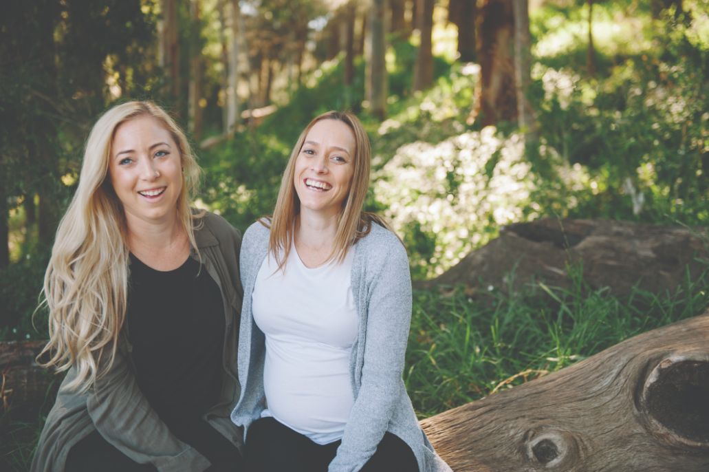 A photo of Emily and Amanda sitting on a log