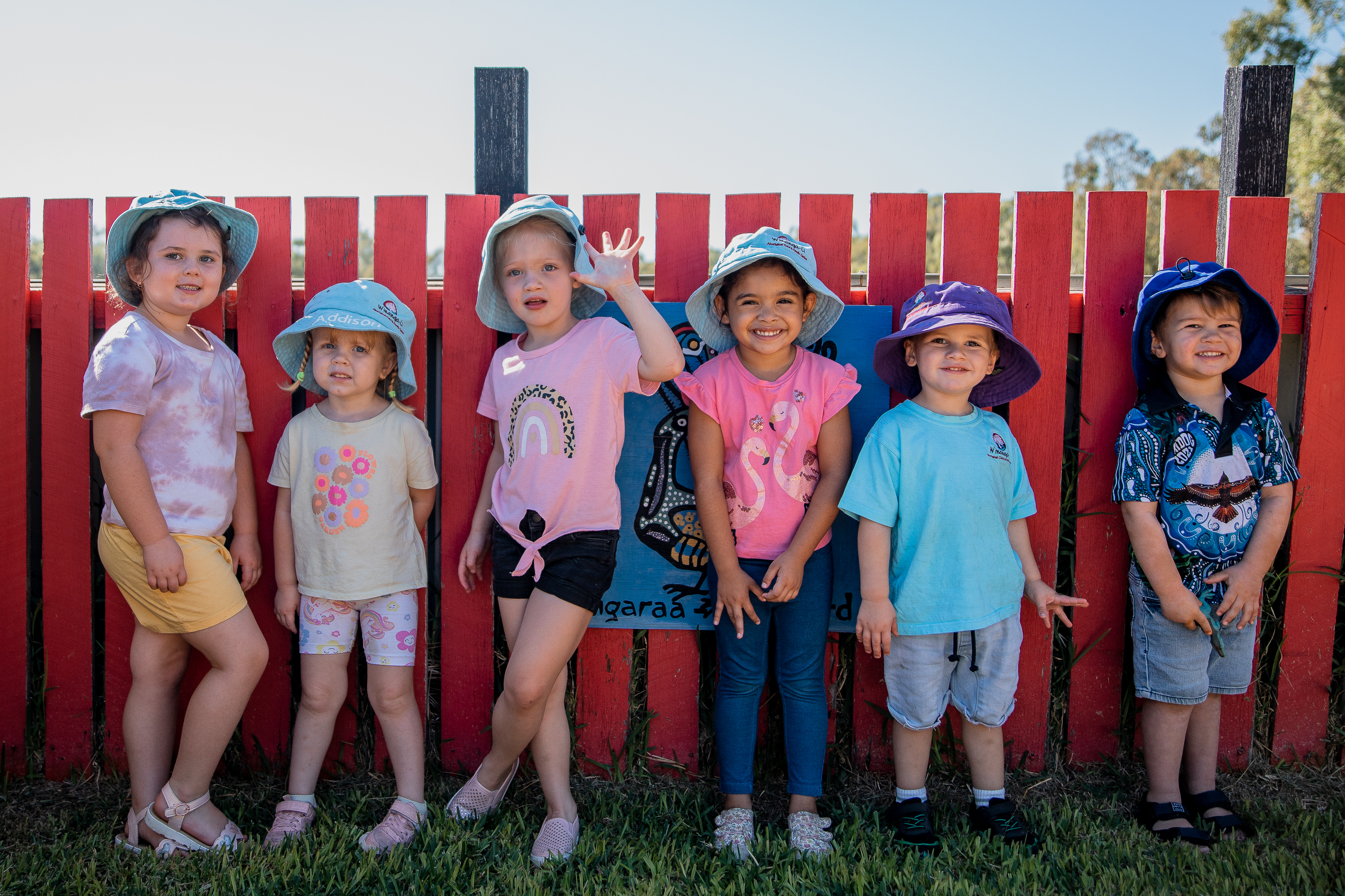 Young children smiling in front of an Aboriginal Child and Family Center