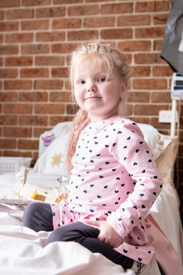 Kim's daughter, Karma sitting on her bed looking at the camera