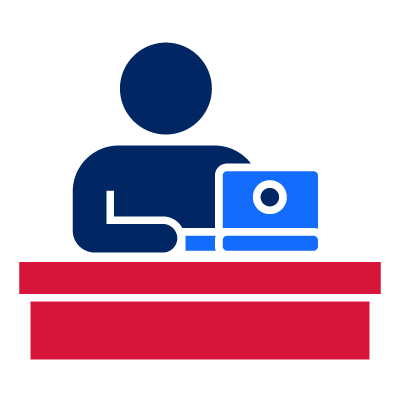Icon of a person sitting at a desk, using a laptop.